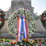 Op de foto staan drie kransen die bij de dodenherdenking op de dam bij het Nationaal Monument zijn geplaatst.