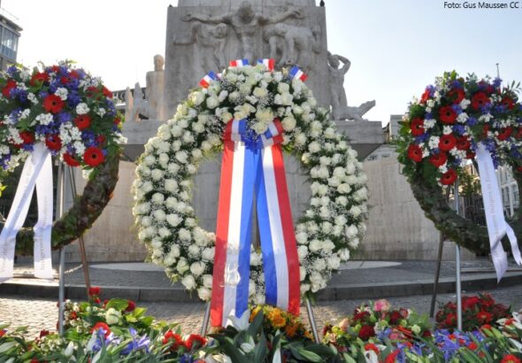 Op de foto staan drie kransen die bij de dodenherdenking op de dam bij het Nationaal Monument zijn geplaatst.