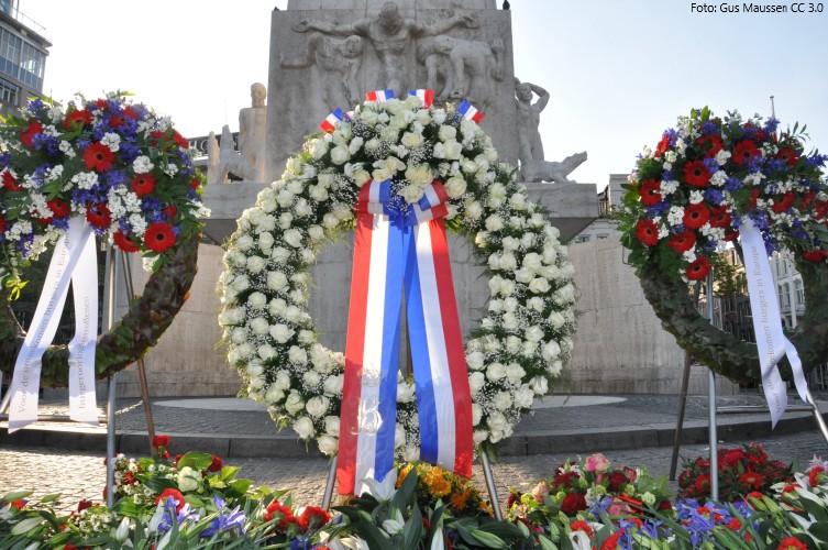 Op de foto staan drie kransen die bij de dodenherdenking op de dam bij het Nationaal Monument zijn geplaatst.