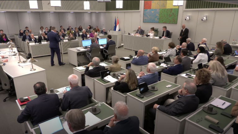 Op de foto is de vergadering van de Eerste Kamer te zien. Bij de interruptiemicrofoon staat senator A.J.A. Beukering van de fractie Beukering die een stemverklaring aflegt.